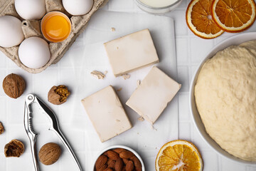 Yeast and ingredients for dough on white tiled table, flat lay