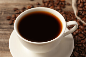 Fototapeta premium Cup of aromatic coffee on wooden table, closeup