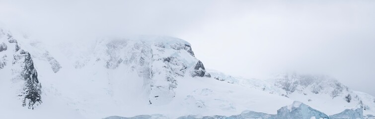 Fototapeta na wymiar The jagged rock, icy layers, and snow create the terrain of Antarctica. 