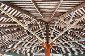 Part of the wooden roof structure on the gazebo. The inside roof of a wooden garden gazebo, looking up