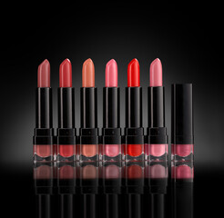 Set of lipsticks in red and natural colors, studio photo on black background. Copy space for your text, high resolution product.