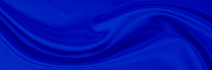 Black blue satin dark fabric texture luxurious shiny that is abstract silk cloth background with patterns soft waves blur beautiful.