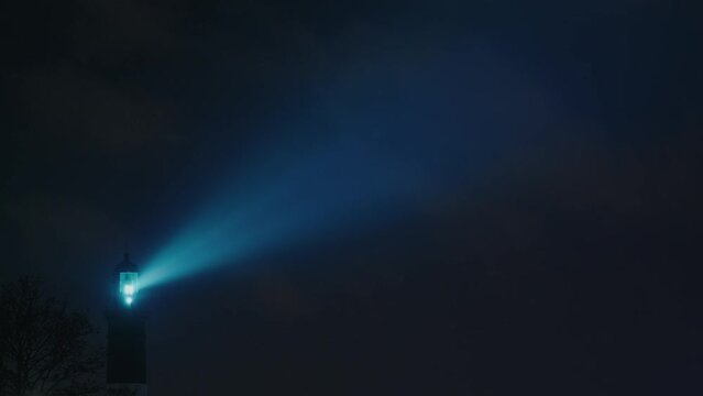 Blue light flashes through the lighthouse in the dark, Static shot