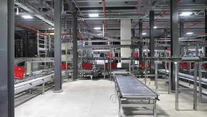 Automated packaging line in ecommerce warehouse, baskets move on conveyor belt to complete online order