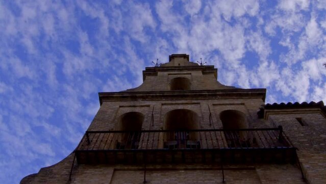 fleecy clouds over church tower on a wide spectacular angle during a sunset rural spanish andalucia sierra jamones old white villages of the Sierra de Aracena, Huelva Jabugo 