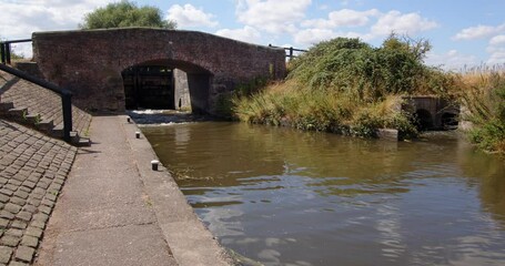 Wide shot off Aston Lock on the Trent and Mersey Canal with water emptying out of the canal through sluice gates