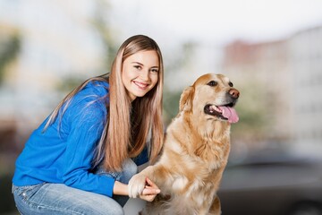 Happy young woman play with a dog on outdoors