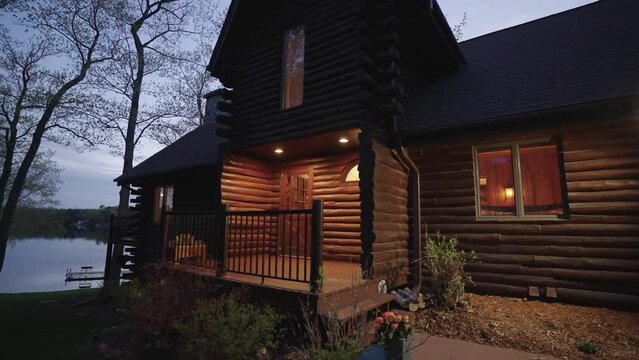 Exterior of a beautiful luxurious wooden lakeside cabin in the woods in the evening