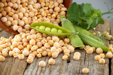 Peas spilling from a rustic bowl on wood table