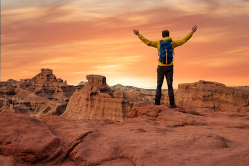 Hiker open arms at mountain peak reaching life goal, freedom, success and happiness, achievement in...
