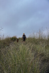 A woman walking around plantation with the dogs.