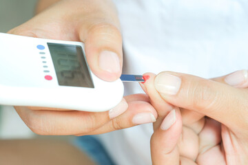 hand of people check diabetes and high blood glucose monitor with digital pressure gauge. Healthcare and Medical concept.