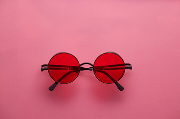 Stylish glasses with red lenses on a red background.
