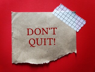 torn brown paper on red backgroud with text written DON'T QUIT, to encourage to try one more time, never give up and overcome obstacles to be success