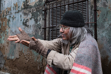 Homeless old man reaching out to passerby ask for money, need for help, Poverty man no home meet financial crisis ask for food live on sidewalk. donate and charity concept.