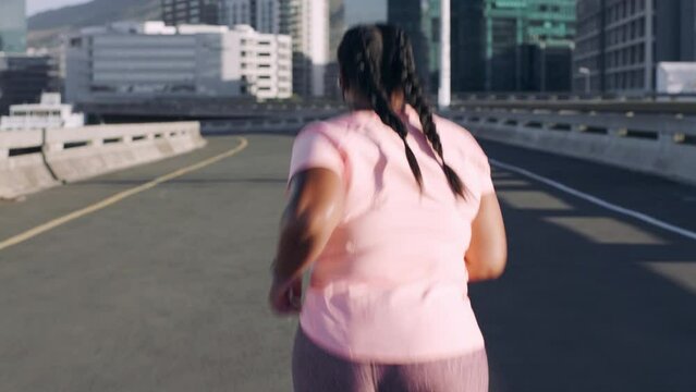 Running, runner and woman with fitness in street, city and exercise outdoor. Sweat, cardio and energy with plus size athlete and weightloss. Wellness, urban and workout with run and sports back view.