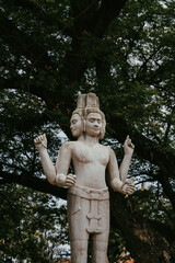 Fototapeta na wymiar Buddhist statue in Siem Reap, Cambodia in front of trees on the river - culture, beauty, travel