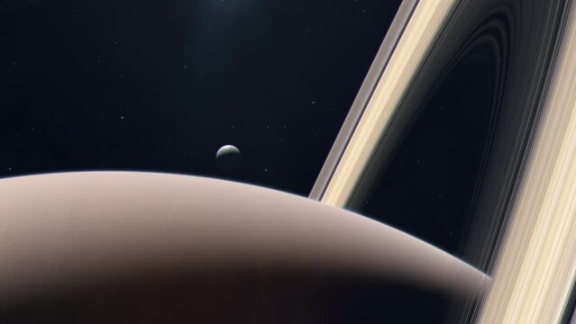 Saturn's Moon Tethys Rising From Behind the Gas Giant Planet