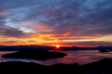  鮮やかな色彩の夜明けの空と上から見下ろす湖。日本の北海道の美幌峠の日の出。