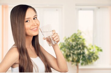 Happy young woman smiling and drinking water