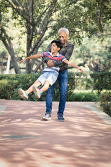 Grandfather having fun with cute grandson at park
