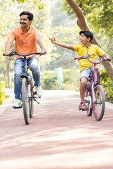 Young father and son having fun riding bicycle.
