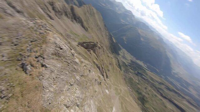 Spinning FPV aerial view  above Esterri D'aneu majestic eroded mountain slope, Catalonia. Spain