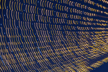 Abstraction blurred movement lights garlands. Golden lights of a blurred garland on the background...