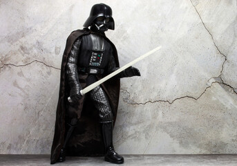 Naklejka premium Bologna - Italy - December 1, 2022: Darth Vader costume replica with light saber. Darth Vader is a character of Star Wars saga.
