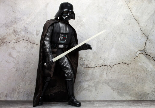 Bologna - Italy - December 1, 2022: Darth Vader costume replica with light saber. Darth Vader is a character of Star Wars saga.