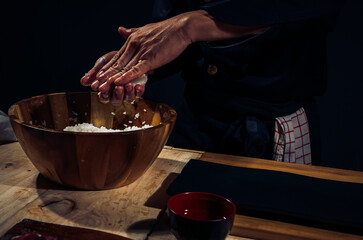 Fototapeta na wymiar Japanese chef making rice nigiri sushi with tuna, salmon, shrimp,traditional Japanese food ,Dark Tone