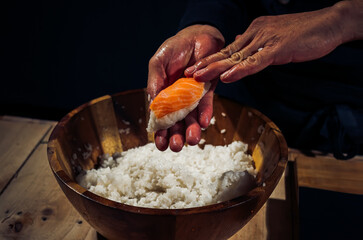 Japanese chef making rice nigiri sushi with tuna, salmon, shrimp,traditional Japanese food ,Dark Tone