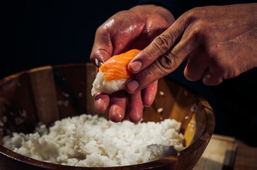 Japanese chef making rice nigiri sushi with tuna, salmon, shrimp,traditional Japanese food ,Dark Tone