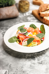 Salad with salmon, sheep cheese, herbs and tomatoes. Mediterranean diet. Delicious and healthy food recipes. Vertical shot. Copy space.