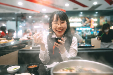 Happy young asian woman japanese thai student eating shabu japan sukiyaki restaurant.