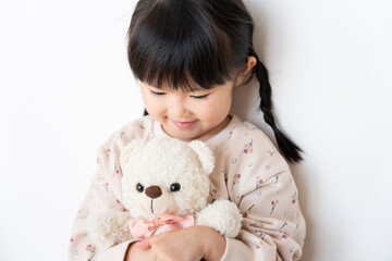 お気に入りのクマのぬいぐるみを抱っこする子供（育児・子育て・プレゼント・5歳）