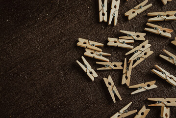 wooden clothespins for clothes scattered on a brown background 1