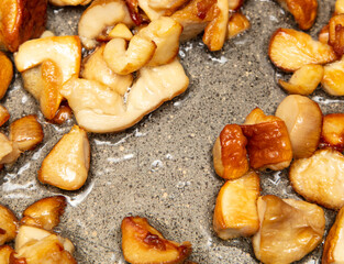Fried mushrooms in oil in a frying pan.