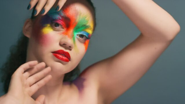 Fashion, makeup and color with woman and face art, colorful aesthetic with cosmetics beauty portrait against studio background. Rainbow, facial and lipstick, creative marketing and hand frame.