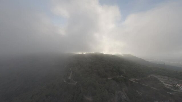 Aerial view into stormy cloud cover over El Cavall Bernat, Alella mountains peak, Catalonia