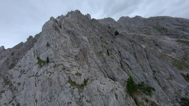 FPV aerial view rising to Esterri D'aneu rocky alpine woodland mountain peaks, Catalonia, Spain