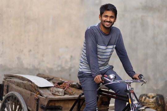 A Rickshaw puller taking away scrap