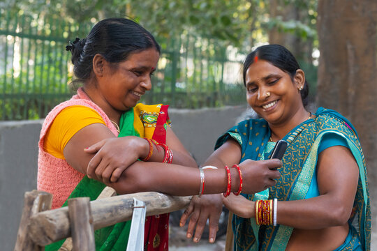 Two maids standing and chatting on the street 