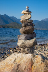 Fototapeta na wymiar Rocks Standing on the beach. Rock balancing on ocean beach, stones stacking by sea water waves