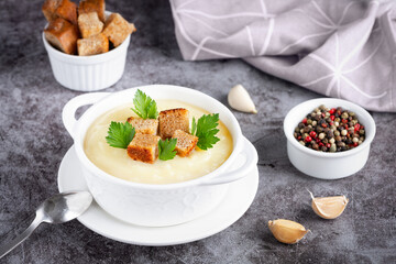 Cauliflower potato soup puree on stone background, Creamy cauliflower soup with toasted bread croutons