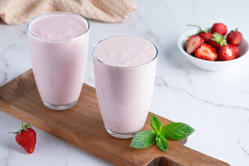 Yogurt , buttermilk or kefir with strawberry. Yogurt in glass on light background. Probiotic cold fermented dairy drink. Gut health, fermented products, healthy gut flora concept - obrazy, fototapety, plakaty
