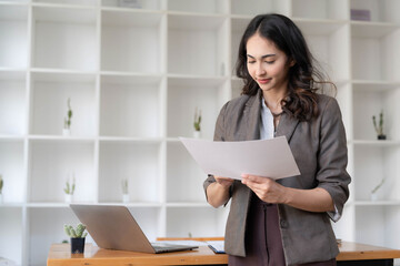 Beautiful Asian businesswoman standing confidently preparing for work.