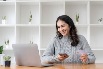 Happy asian Business woman pay online using mobile phone at the office.