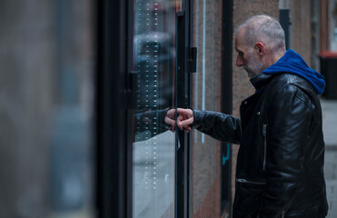 Adult man buying on automatic vending machine on street.