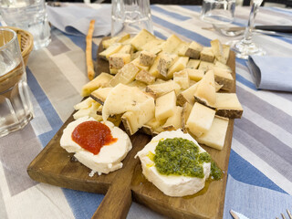 Cheese variety tapas on wooden cutting board. Traditional Spanish snack food, appetizer concepts